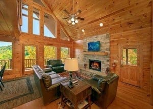 log cabin living room looking out on mountains with dark furniture