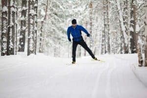 A man cross-country skiing in the snow.