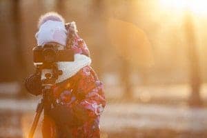 Woman taking a photo in the winter with a tripod.