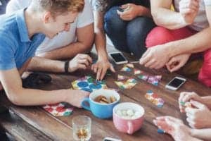 Friends enjoy playing a board game at their cabin